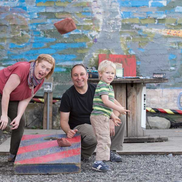 Kid and parents throwing a bean bag.